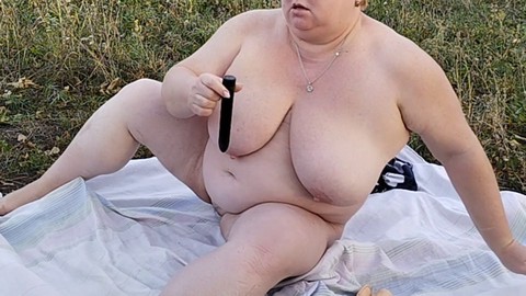 Une MILF joue avec des sextoys en plein air et se salit de près
